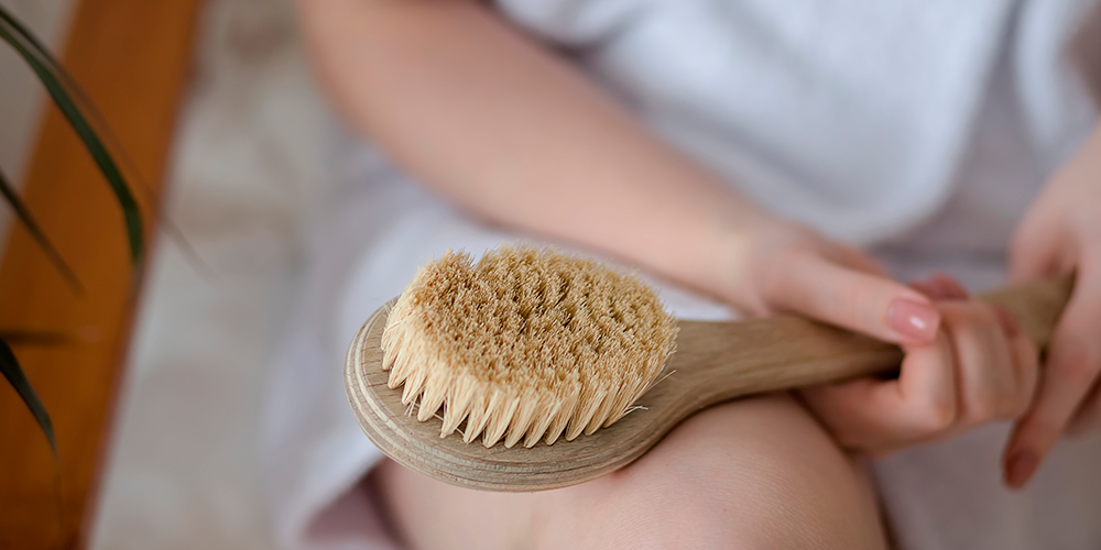 A women with her sauna accessorie, a sauna brush