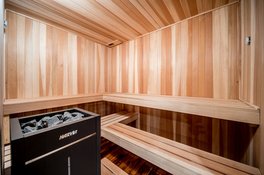 Indoor sauna with wood-paneled walls, tiered benches, and a Harvia electric heater
